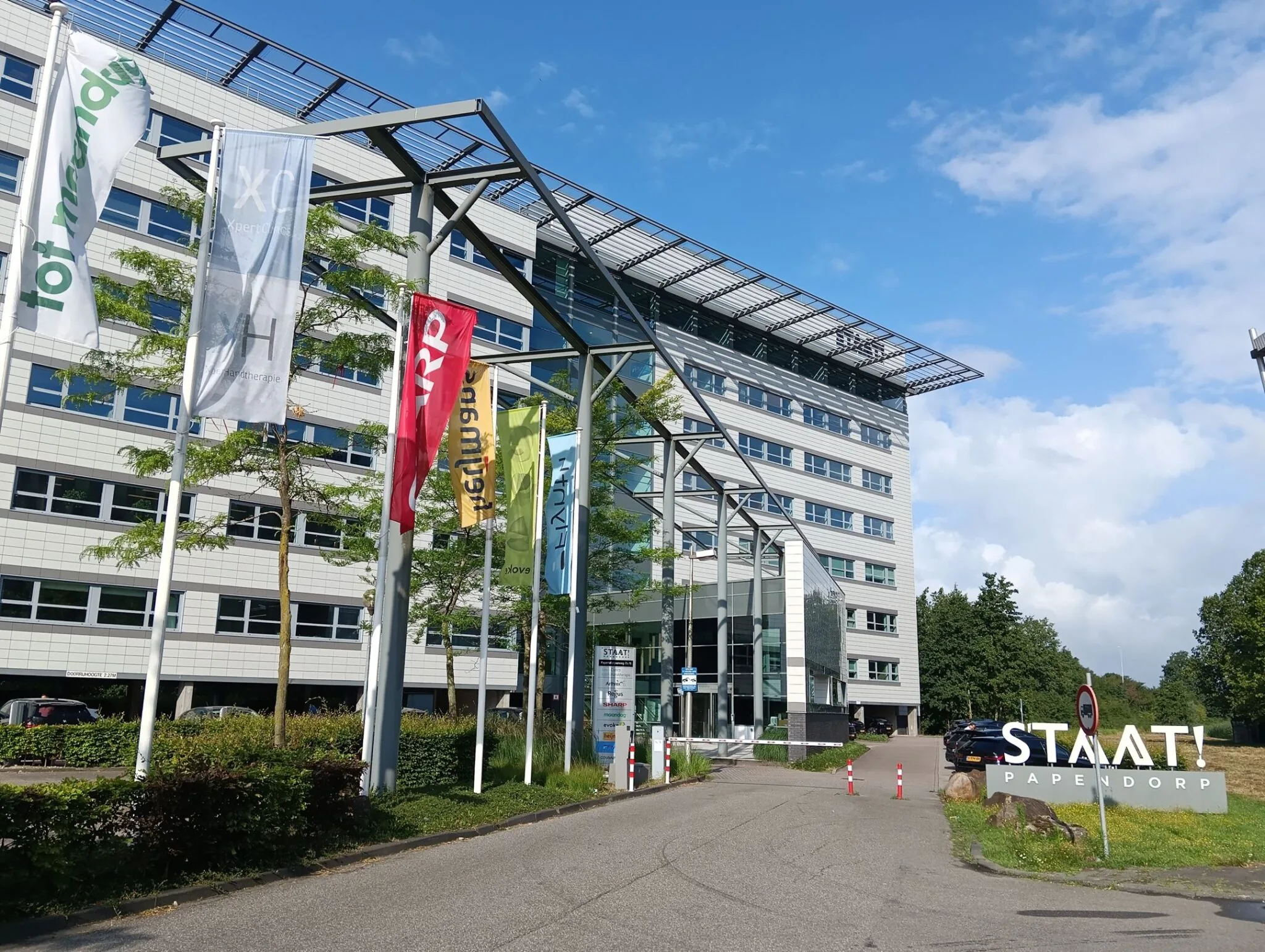 Kantoorgebouw aan de Papendorpseweg 75 in Utrecht met vlaggen en het bord ‘STAAT! Papendorp’ bij de ingang.