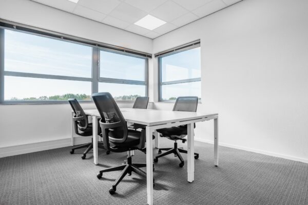 Moderne vergaderruimte met vier bureaustoelen en een witte tafel bij Papendorpseweg 75 met uitzicht op de omgeving.