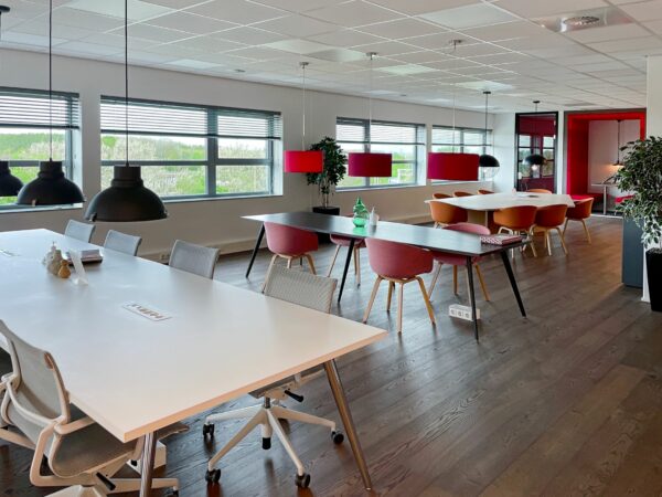 Modern ingerichte kantoorruimte aan de Papendorpseweg 75 met meerdere werktafels, kleurrijke stoelen en hanglampen.