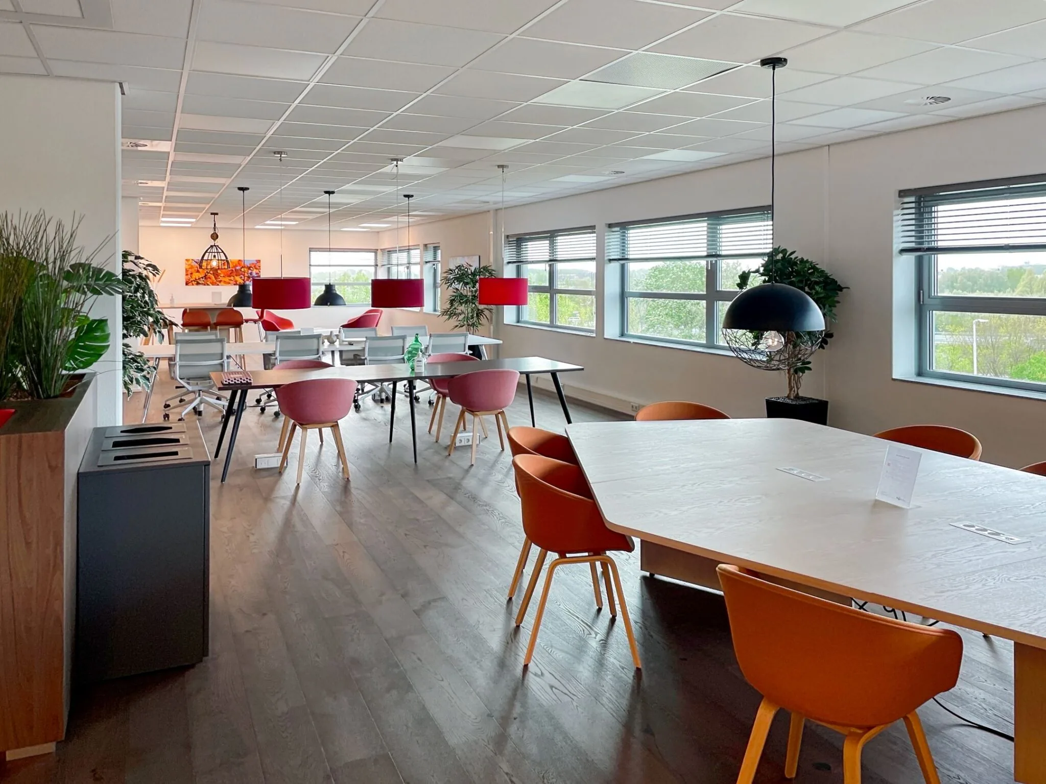 Moderne en lichte kantoorruimte aan de Papendorpseweg 75 met flexwerkplekken, vergadertafels en kleurrijke stoelen.