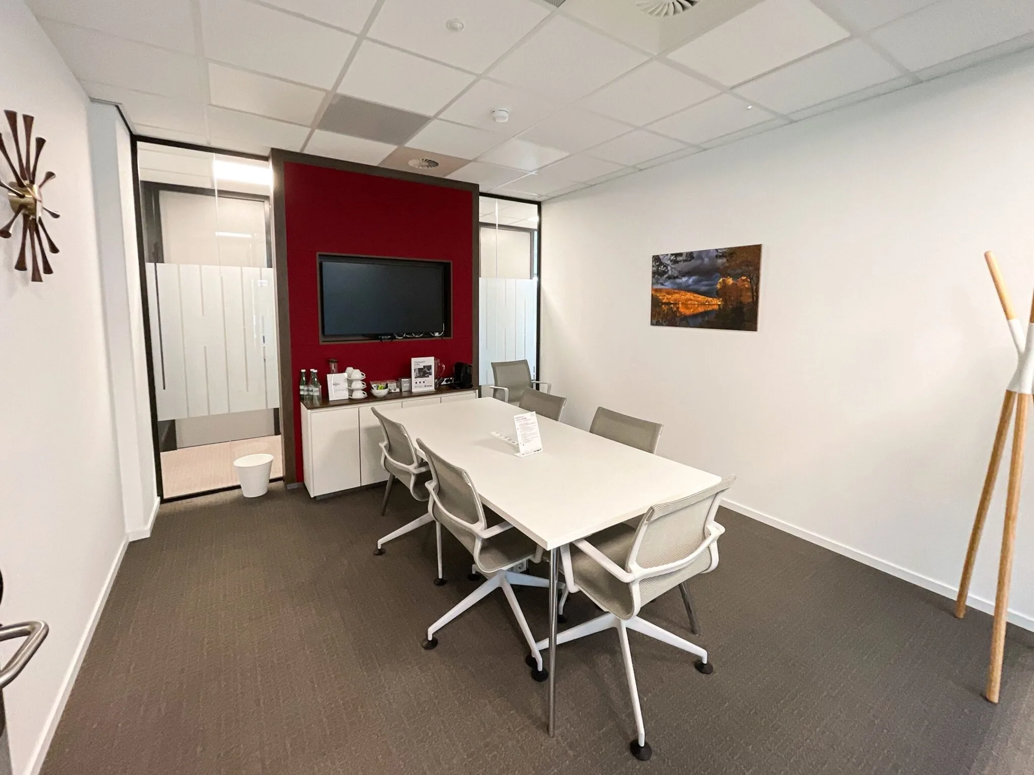 Vergaderruimte aan de Papendorpseweg 75 met witte tafel, zes stoelen, flatscreen en koffievoorzieningen.