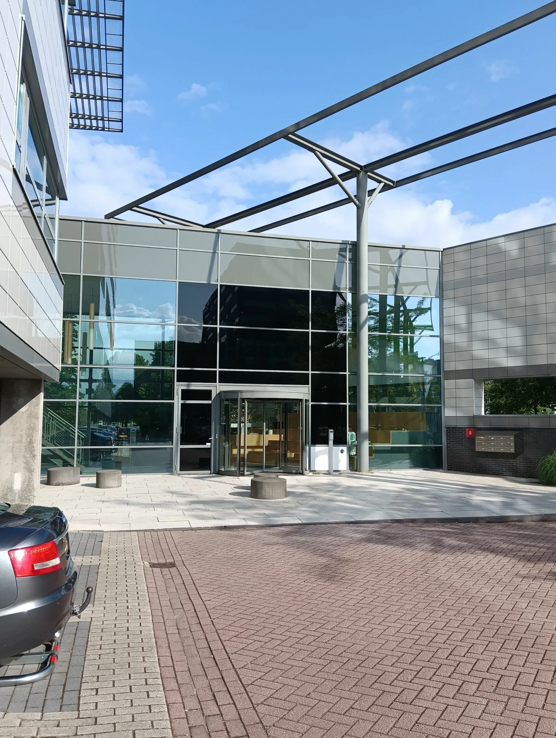 Moderne glazen entree van het kantoorgebouw aan de Papendorpseweg 75 op een zonnige dag.