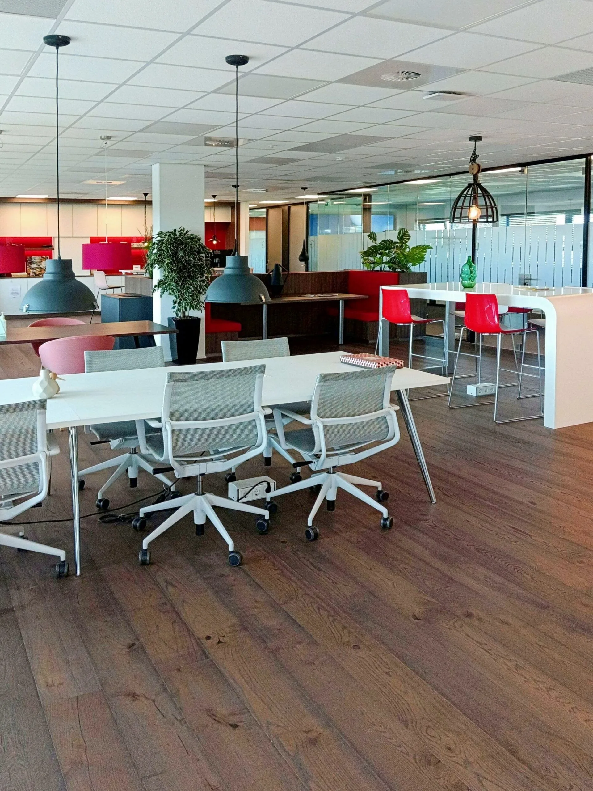 Moderne kantoorruimte aan de Papendorpseweg 75 met witte bureaus, ergonomische stoelen en kleurrijke zitgedeeltes.