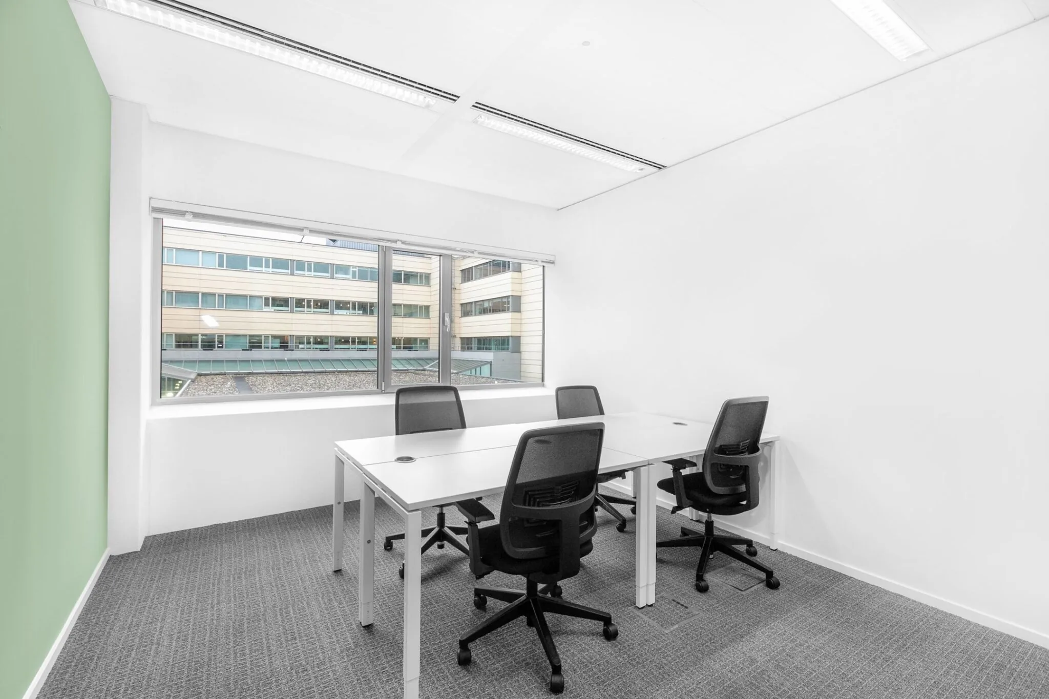 Kleine, moderne kantoorruimte met vier bureaustoelen en uitzicht op het gebouw aan de Papendorpseweg 95.