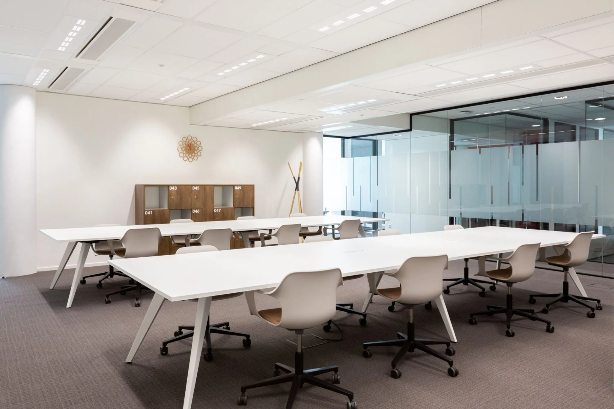 Moderne kantoorruimte aan de Parijsboulevard 209 met witte bureaus, ergonomische stoelen en glazen vergaderruimte.