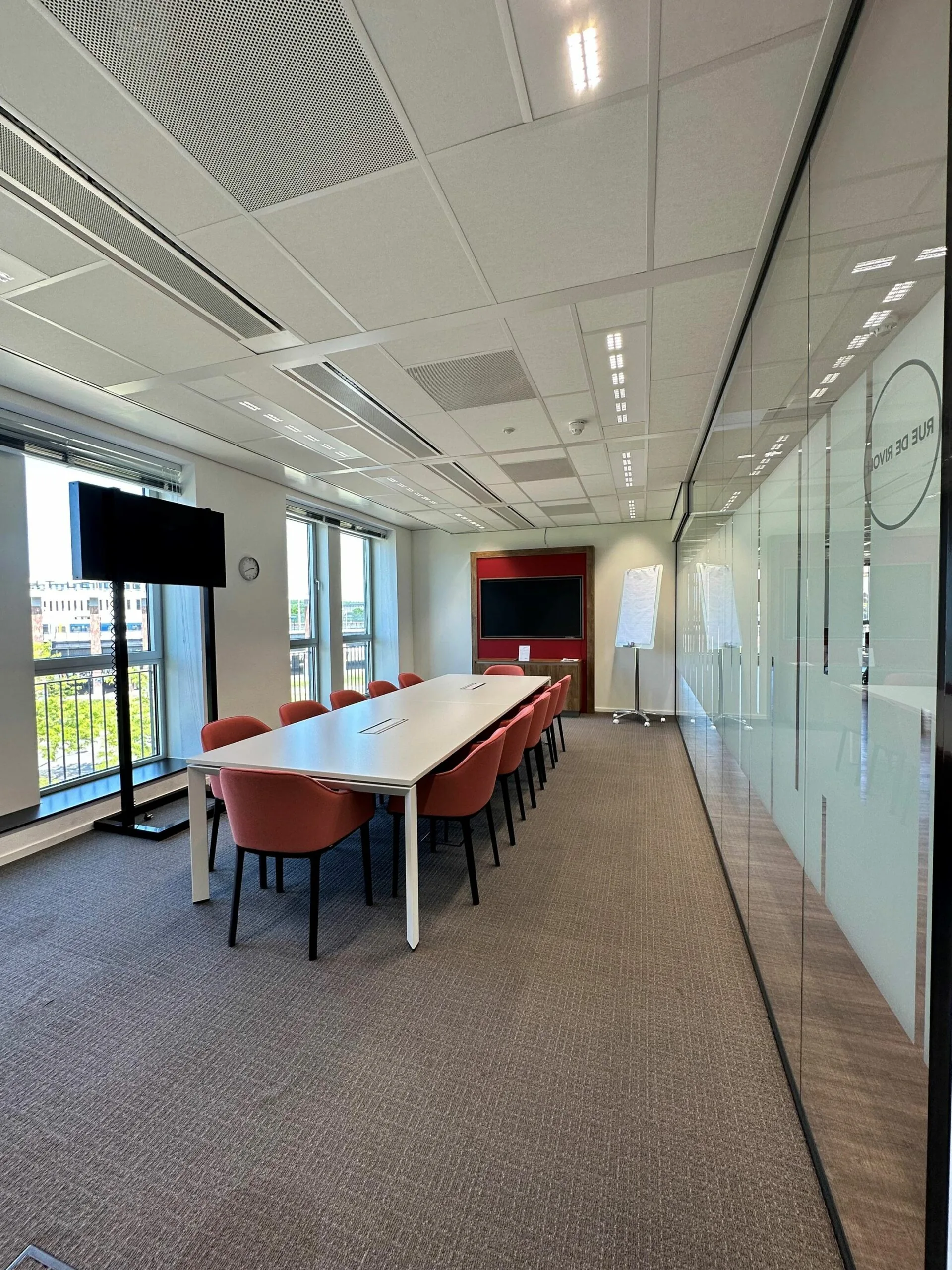 Vergaderruimte met lange tafel en rode stoelen in kantoor aan de Parijsboulevard 209.