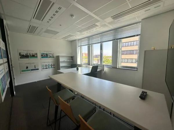 Moderne kantoorruimte aan de Parijsboulevard 209 met werkplekken, grote ramen en informatieve posters aan de muur.