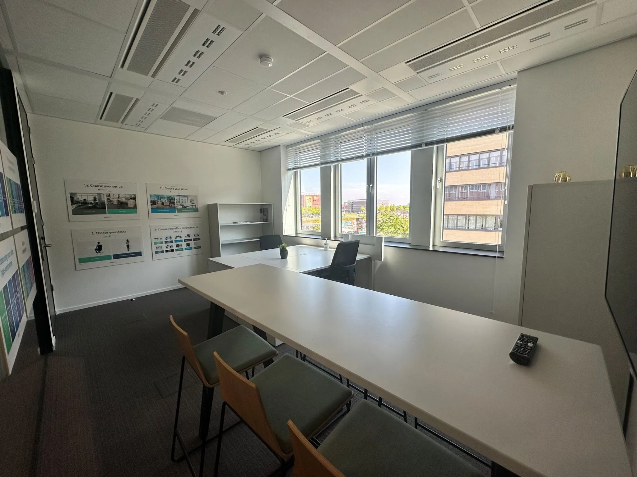 Moderne kantoorruimte aan de Parijsboulevard 209 met werkplekken, grote ramen en informatieve posters aan de muur.