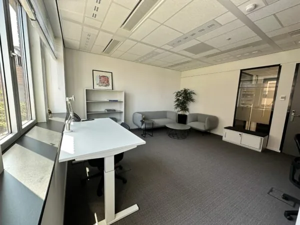 Modern kantoor op Parijsboulevard 209 met zitgedeelte, bureau en grote ramen voor natuurlijk licht.