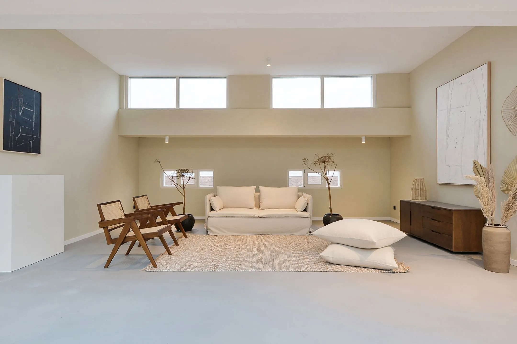 Minimalistisch ingerichte woonkamer in Parkstraat 183_2 met neutrale tinten, een witte bank, houten stoelen en moderne decoratie.