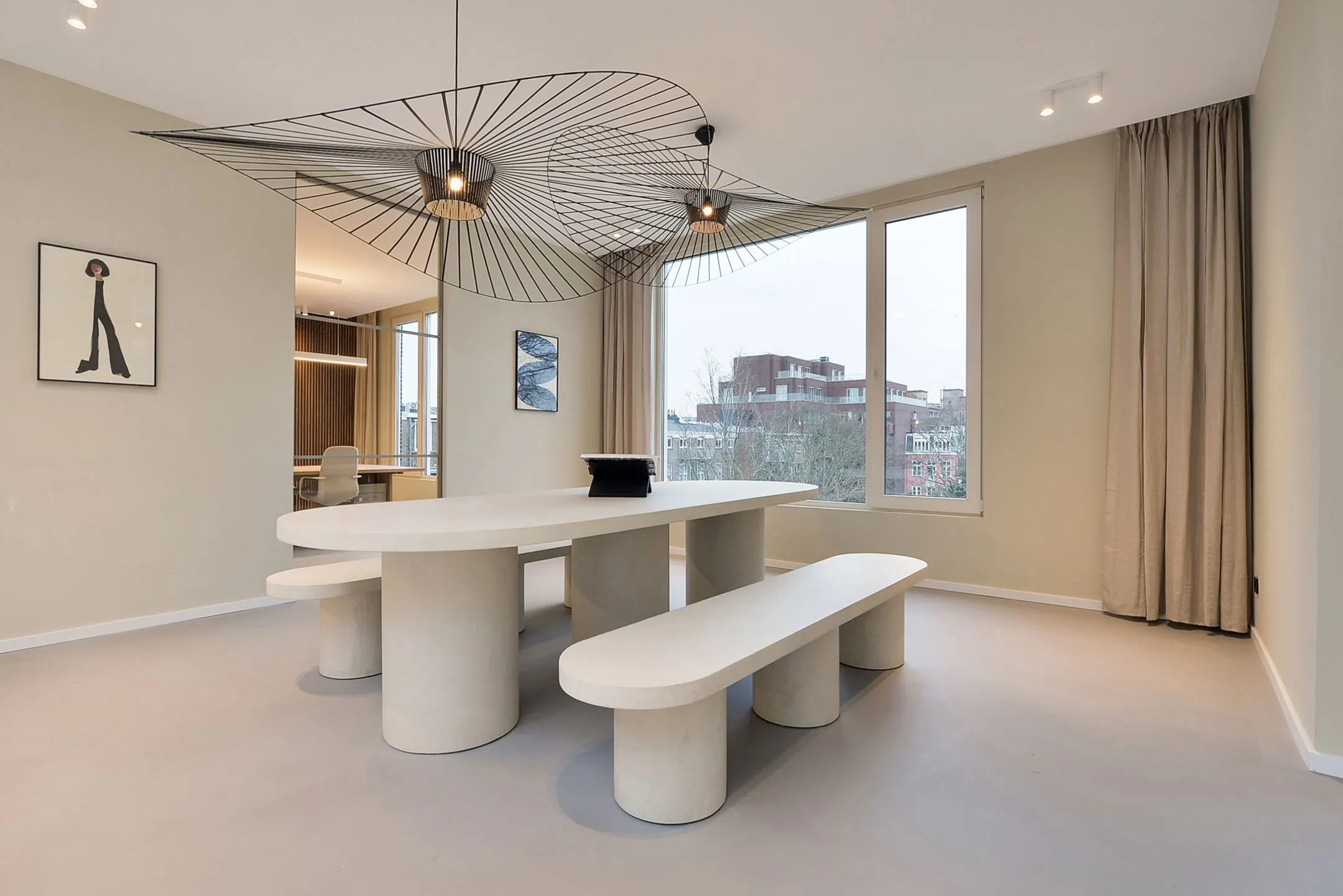 Minimalistisch ingerichte eetkamer in Parkstraat 183_5 met een ovale tafel, bijpassende banken en opvallende moderne plafondlampen.