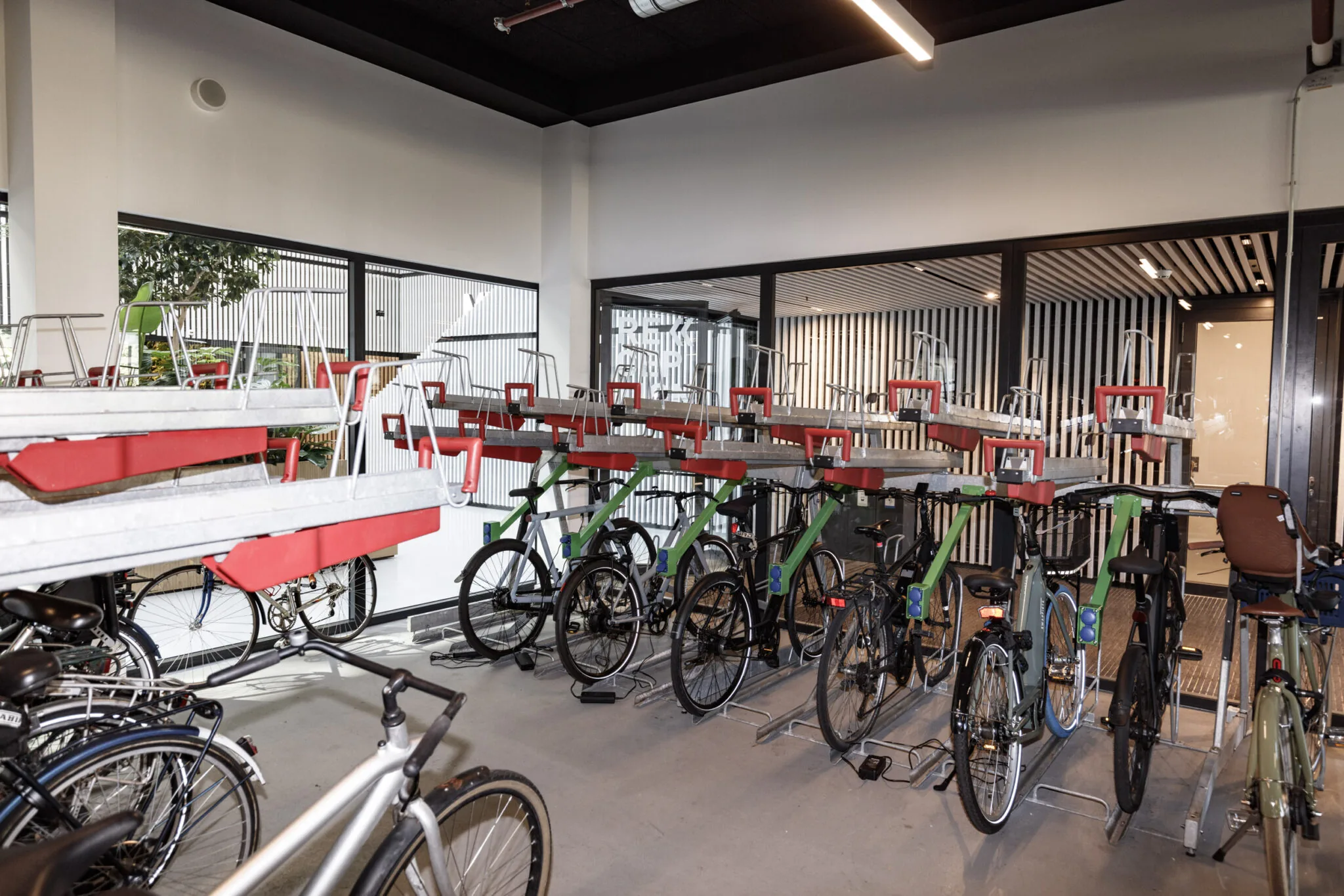 Fietsenstalling met dubbellaags rekken in een moderne, afgesloten ruimte.