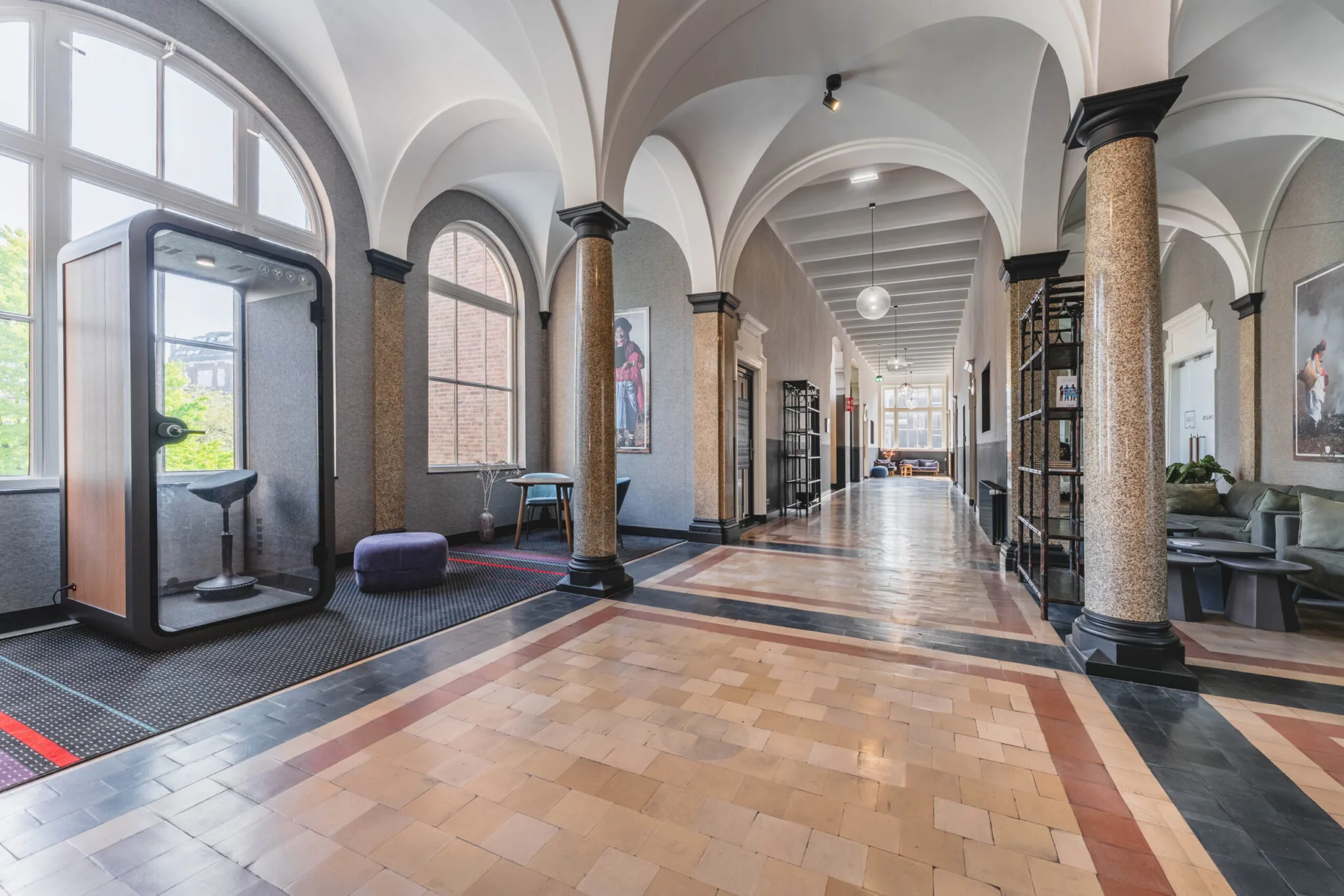 Gerenoveerde gang in Raamplein 1-2 met hoge gewelven, zitplekken en een moderne belcel.