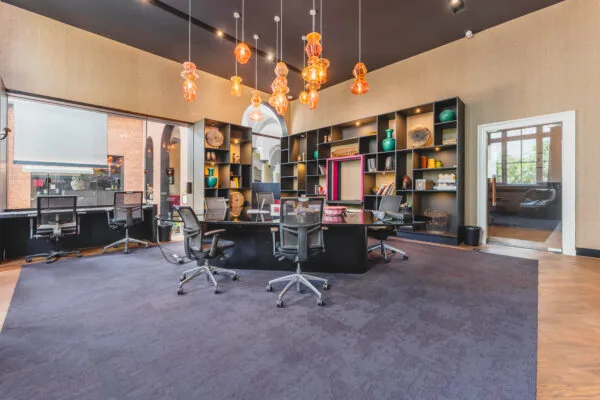 Modern ingerichte kantoorruimte op Raamplein met designverlichting, vergadertafel, bureaustoelen en open wandkasten.