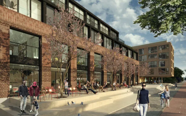 Moderne terrassen met mensen op de Republica Terrace, omringd door bomen en een bakstenen gebouw op een zonnige dag.