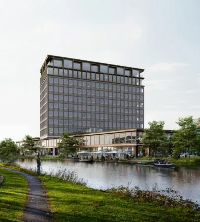 Modern kantoorgebouw aan de Rijnsburgstraat met grote ramen, gelegen aan een waterpartij met wandelpad en groen.