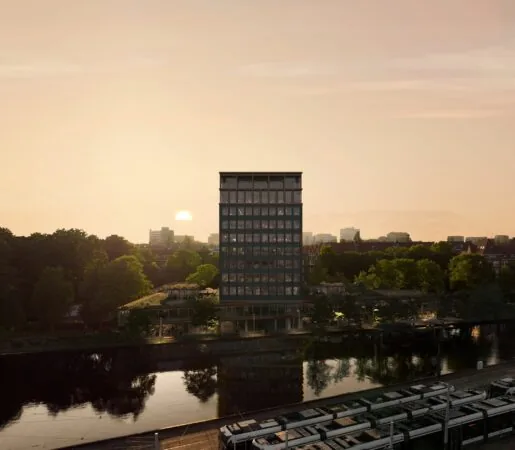 Een hoog kantoorgebouw aan de Rijnsburgstraat weerspiegeld in het water bij zonsondergang.