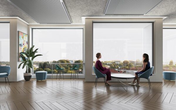 Twee vrouwen zitten in een moderne lounge met grote ramen en uitzicht op Rijnsburgstraat 9.