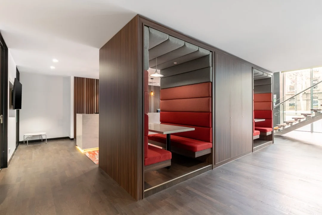 Moderne kantoorruimte met geluidsdichte zitcabines en rode bekleding in Rotterdam Airportplein 22.