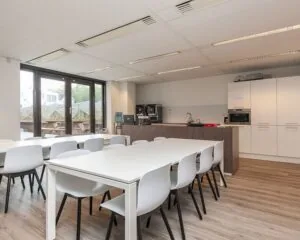 Moderne bedrijfskeuken met zitgedeelte en uitzicht op een terras aan de Schiekade 34 in Rotterdam.