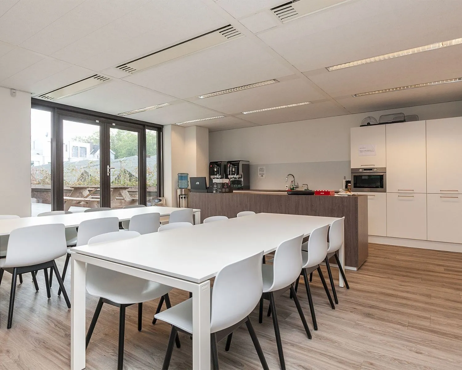 Moderne bedrijfskeuken met zitgedeelte en uitzicht op een terras aan de Schiekade 34 in Rotterdam.