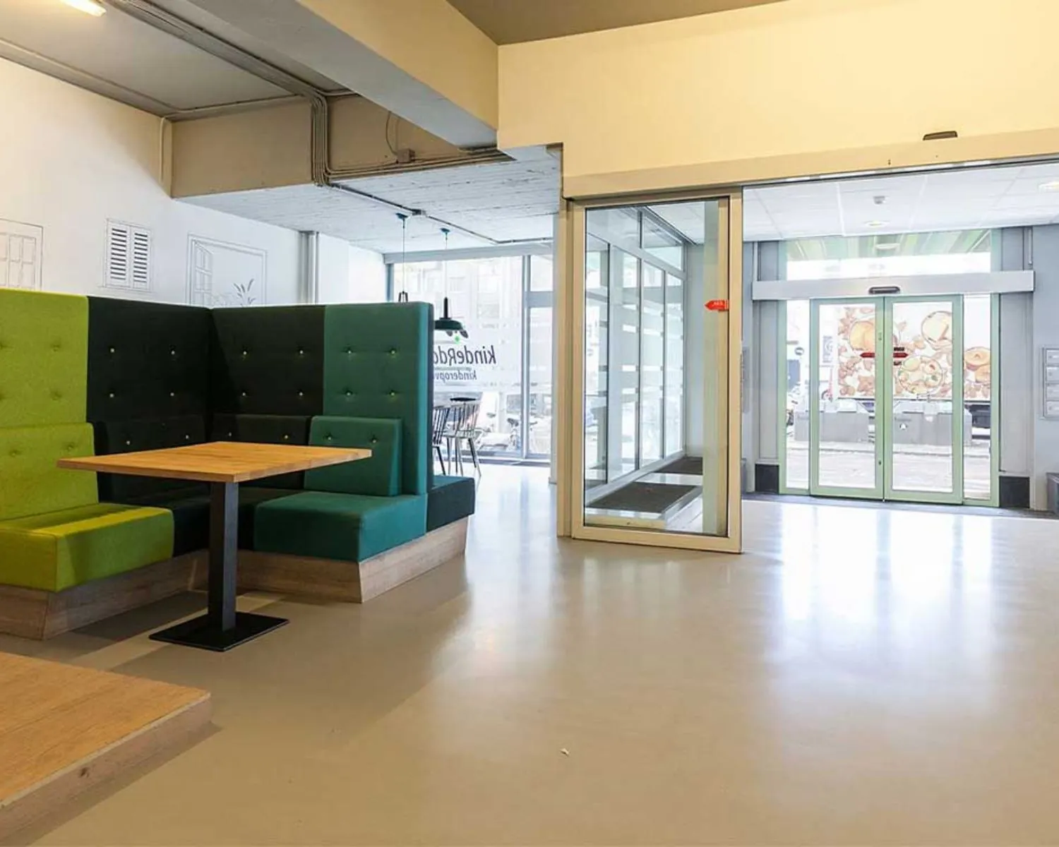 Ingangshal van Schiekade 34 in Rotterdam met moderne zitbanken en glazen schuifdeuren.