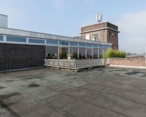 Dakterras met balustrade en plantenbakken op een gebouw aan de Schiekade 34 in Rotterdam.