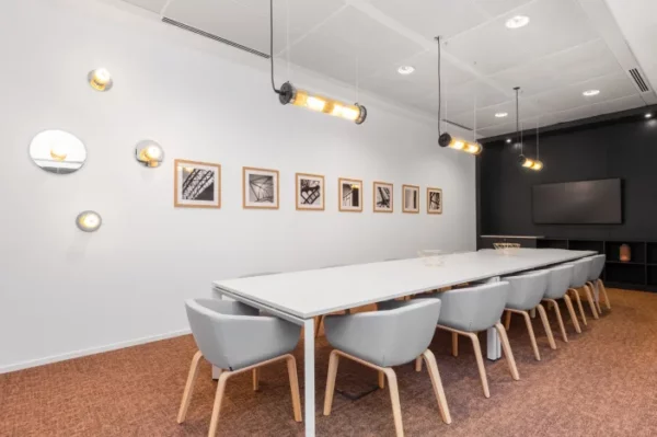 Moderne vergaderruimte in Signature by Regus San Silvestro in Rome met lange witte tafel, grijze stoelen en wanddecoratie.
