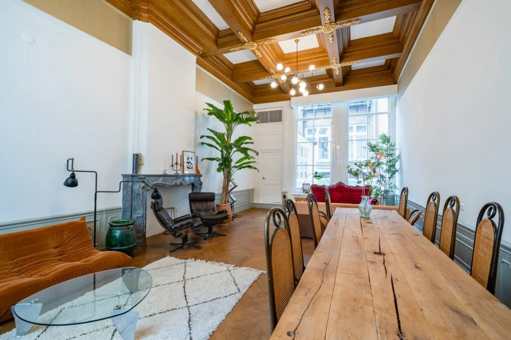Stijlvol ingerichte woonkamer in Singel 258 met houten balkenplafond, lange eettafel en klassieke details.