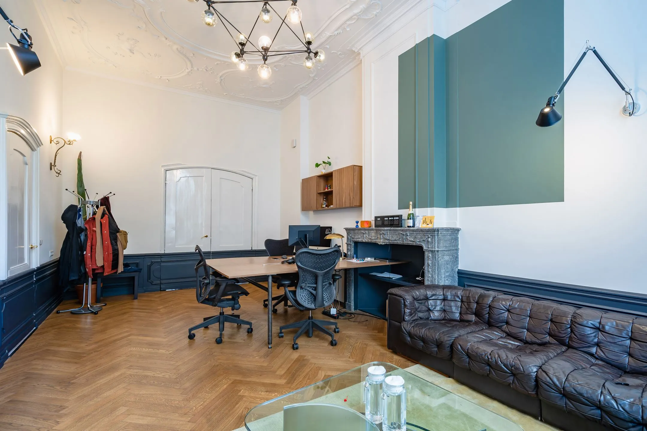 Stijlvol ingericht kantoor in Singel 258 met klassiek plafond, houten vloer, moderne werkplekken en een leren bank.