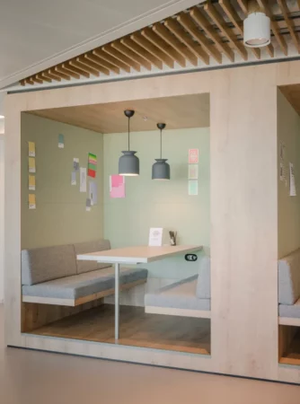 Moderne werkruimte met een ingebouwde zithoek en tafel in het Spaces-kantoor bij Vienna Main Station.