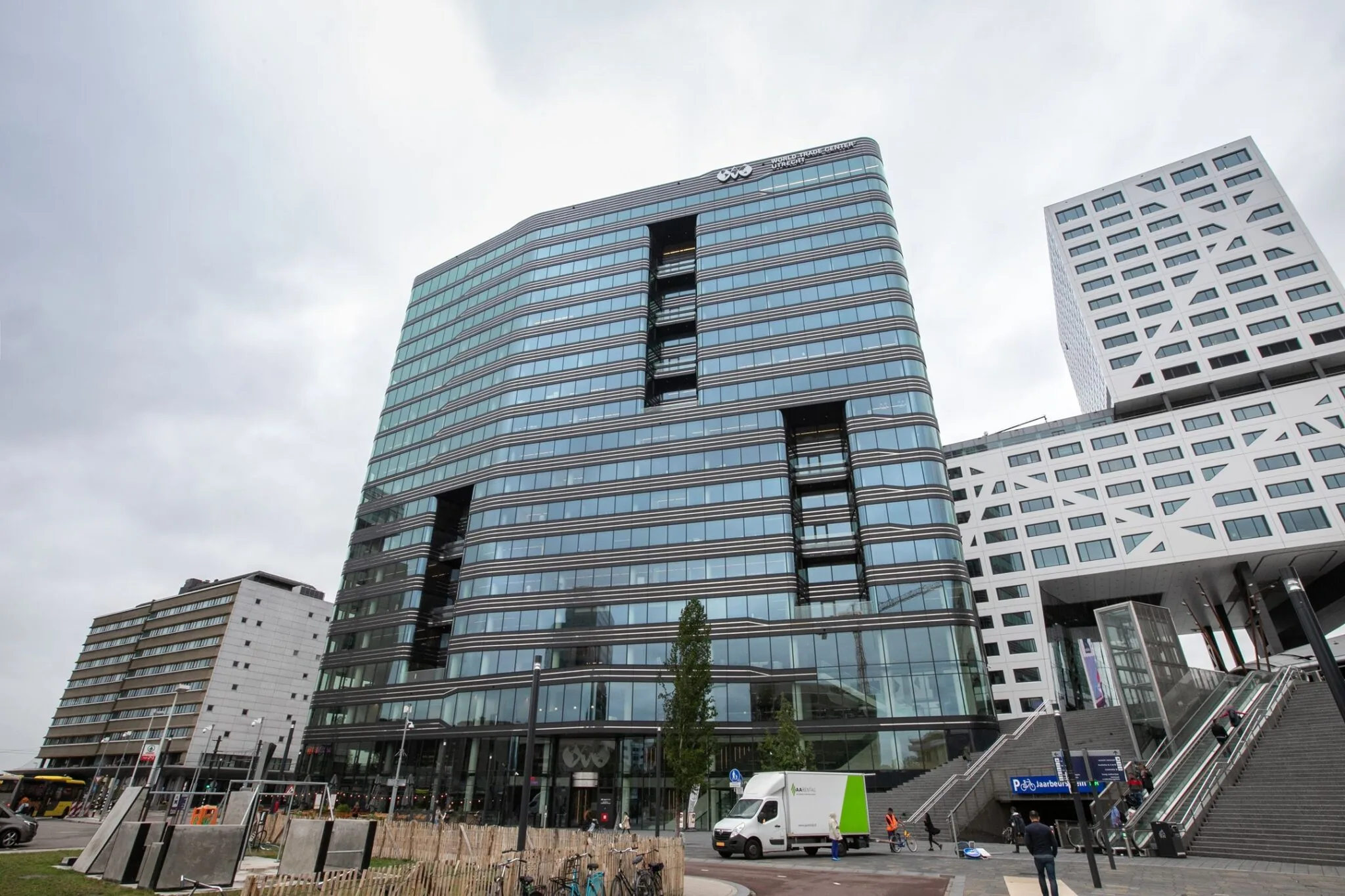 Modern kantoorgebouw Stadsplateau 7 in Utrecht met glazen gevel en naastgelegen trappen naar het Jaarbeursplein.
