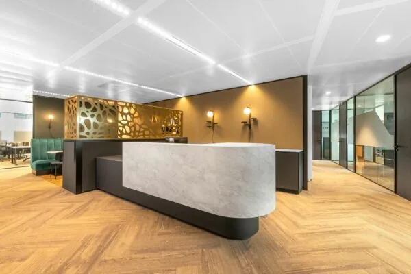 Moderne kantoorruimte met een marmeren receptiebalie, glazen vergaderruimtes en sfeervolle verlichting bij Stadsplateau 7.