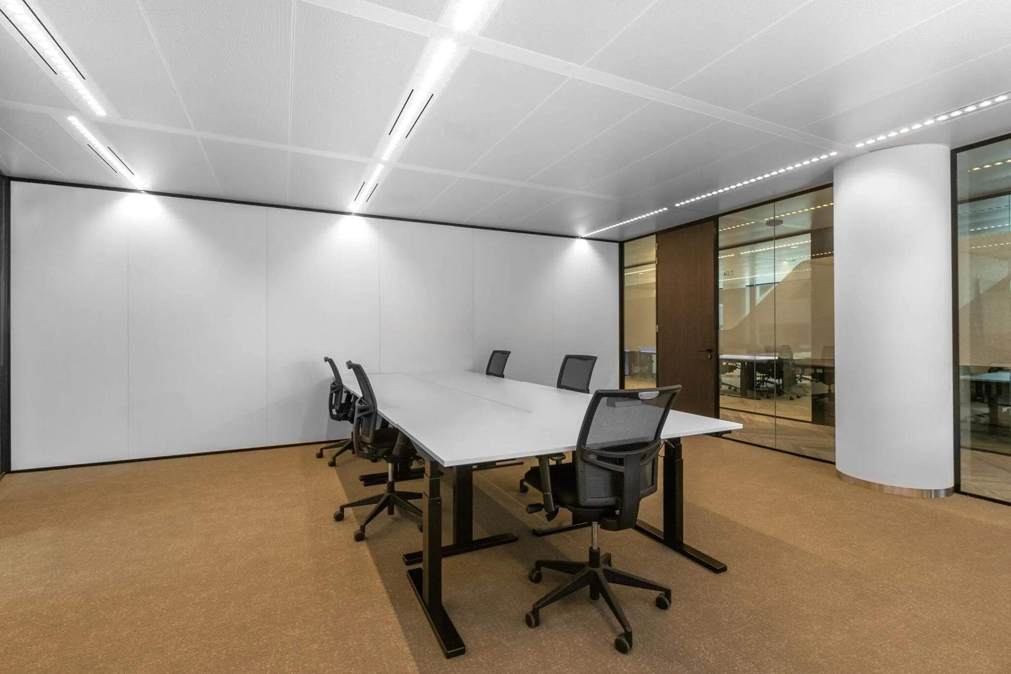 Vergaderruimte met een grote rechthoekige tafel, zes bureaustoelen en glazen scheidingswanden in kantoorpand Stadsplateau 7.