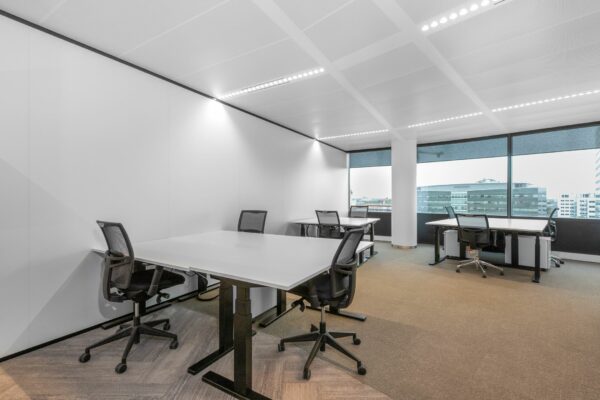 Moderne kantoorruimte in Stadsplateau 7 met meerdere bureaus, bureaustoelen en grote ramen met uitzicht op de stad.