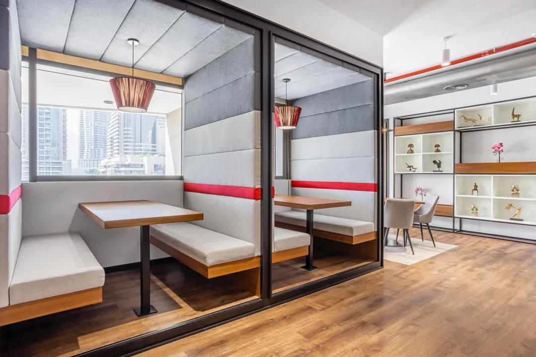 Moderne zithoeken met gestoffeerde wanden en zicht op een stadsgezicht in een kantoorpand aan het Stationsplein 18.