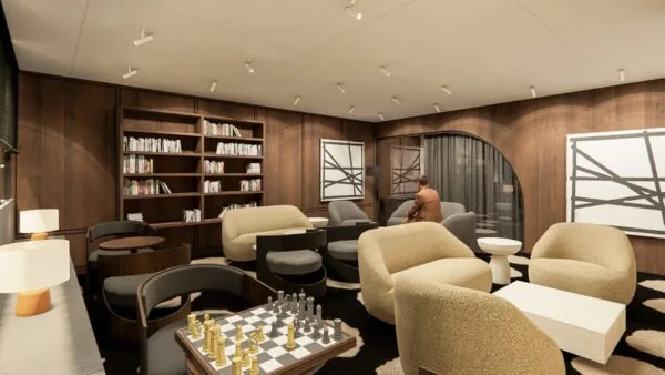 Moderne lounge aan de Strawinskylaan met comfortabele zitplaatsen, boekenrekken, abstracte kunst en een schaaktafel.