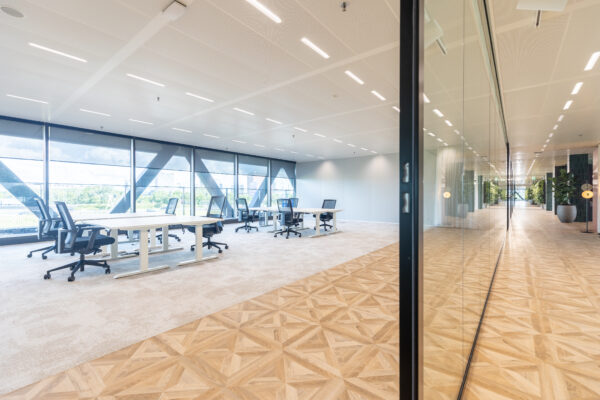 Modern en licht kantoorinterieur in The Joan-30 met ruime werkplekken, glazen wanden en uitzicht op de stad.
