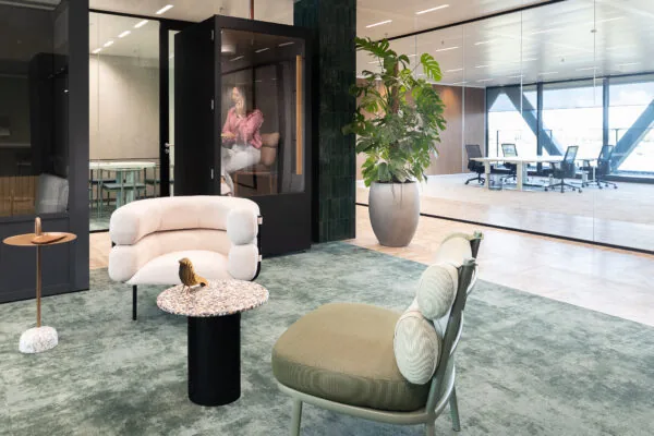 Moderne kantoorruimte in The Joan met designmeubilair, een belcel en glazen vergaderruimtes.