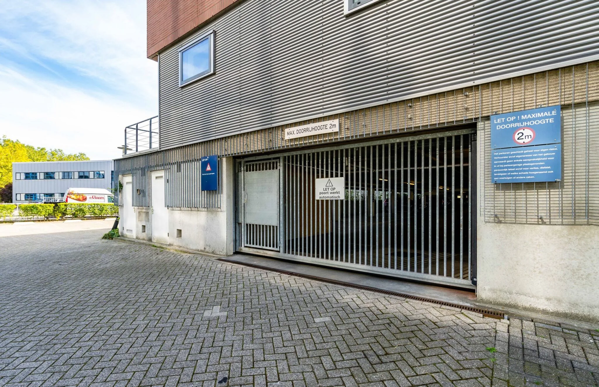Ingang van parkeergarage aan de Tielweg 30 met een automatische poort en een maximale doorrijhoogte van 2 meter.