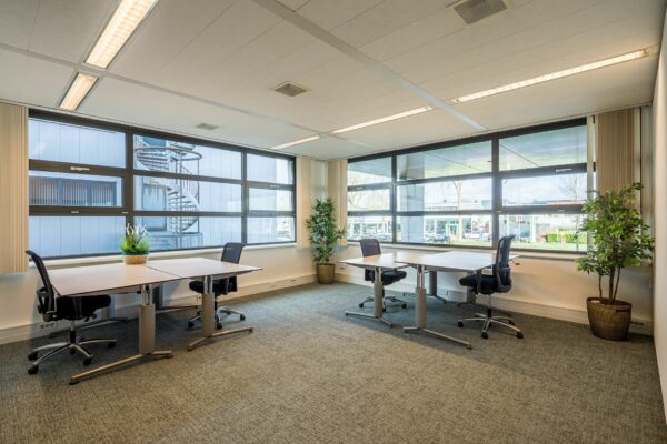 Lichte en moderne kantoorruimte aan Tielweg 30 met vier werkplekken en grote ramen met uitzicht naar buiten.