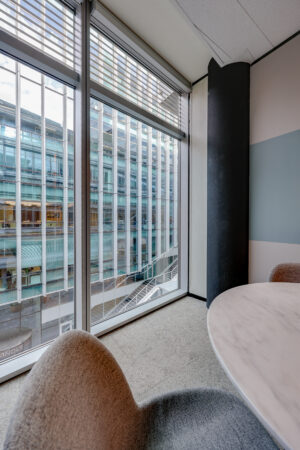 Een moderne kantoorruimte met een raam dat uitzicht biedt op een architecturaal gebouw.