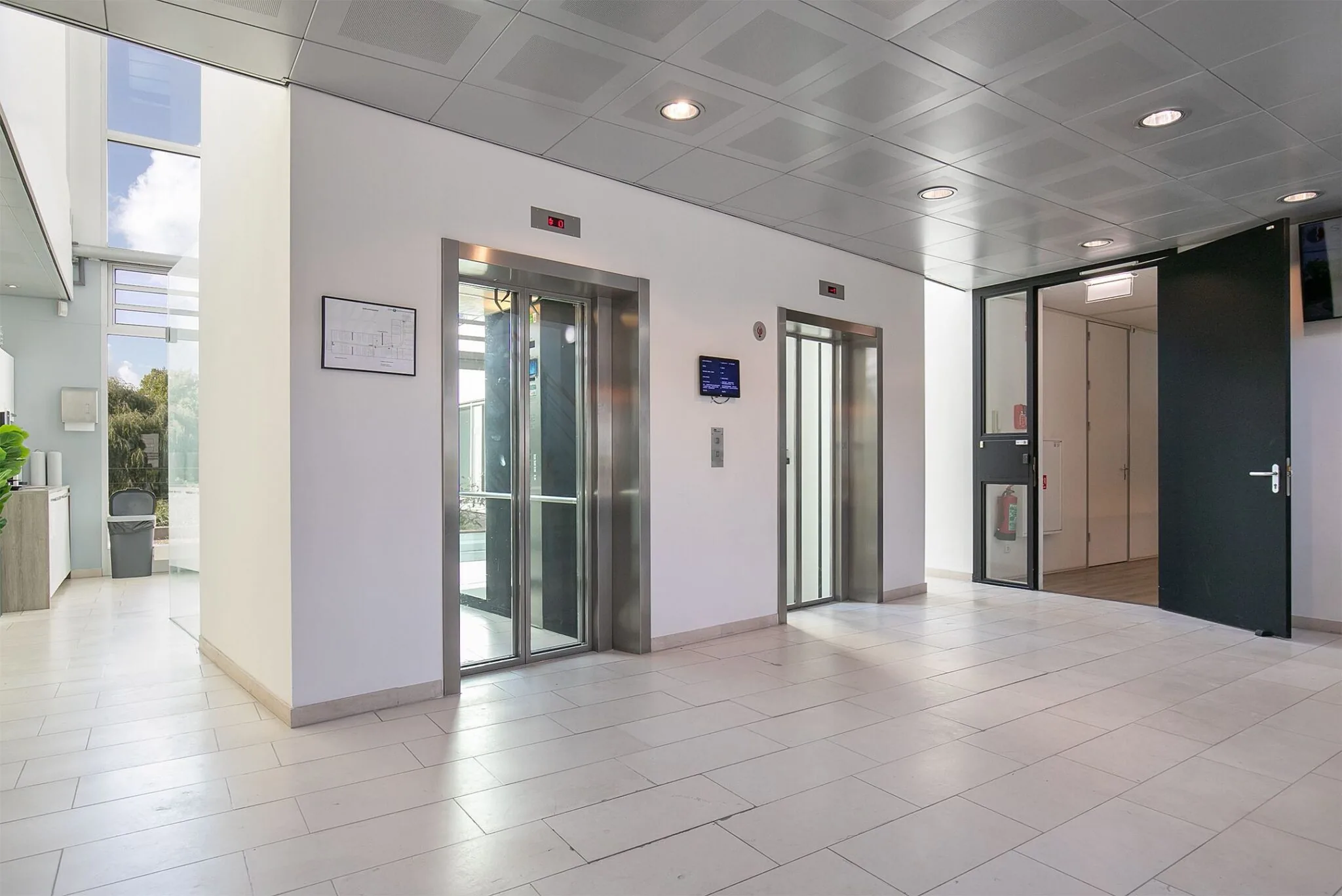 Moderne lichte entreehal met twee liften in kantoorgebouw Tupolevlaan 41.