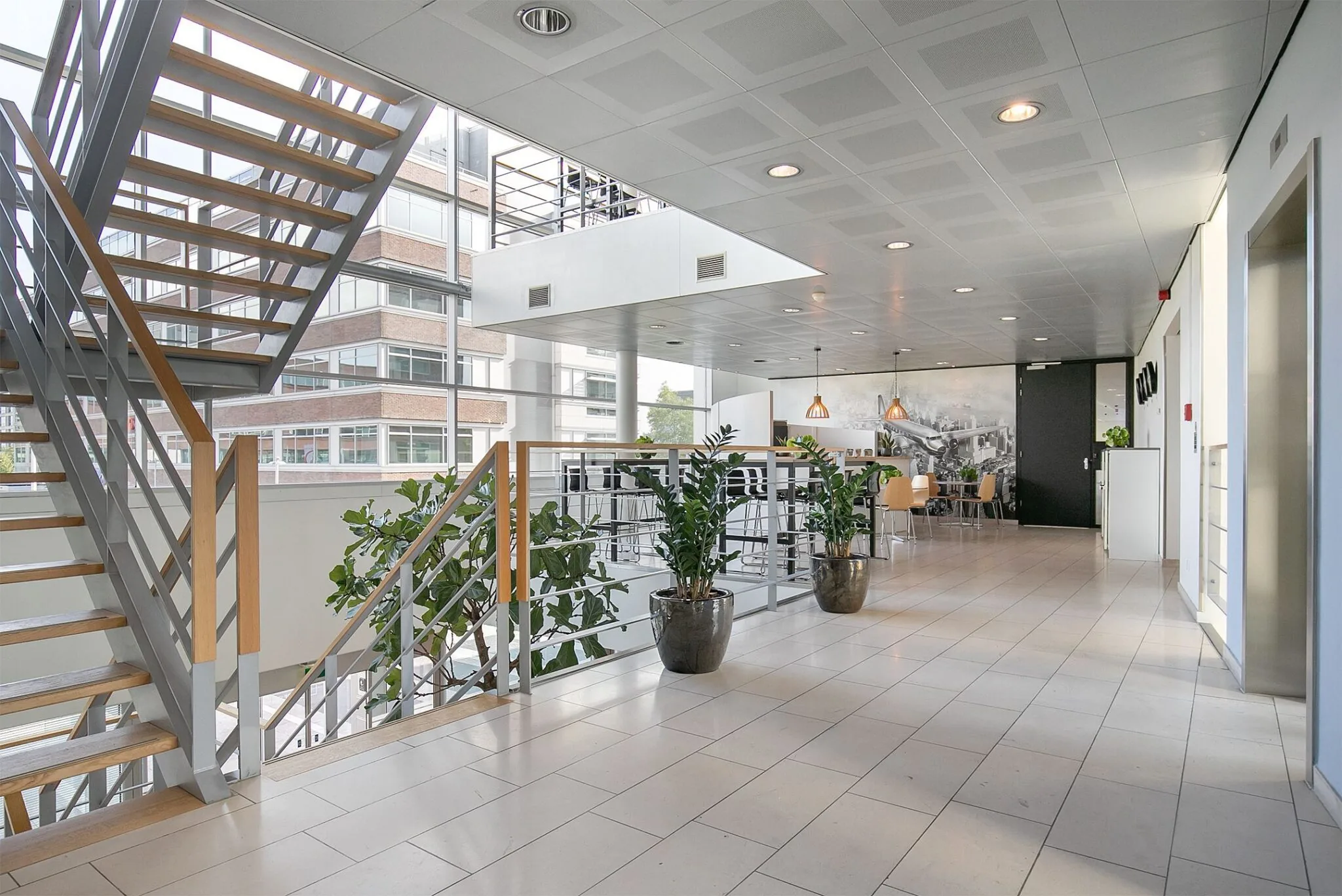 Moderne kantoorruimte aan de Tupolevlaan 41 met een open trap, zithoek en grote ramen.