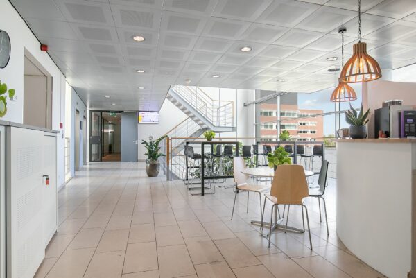 Moderne en lichte kantoorruimte aan de Tupolevlaan 41 met zitgedeelte, koffiecorner en trap naar boven.