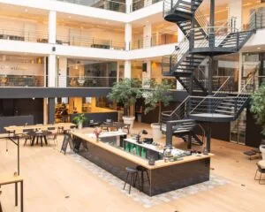 Moderne, open kantoorruimte in Utrecht met centraal gelegen koffiebar en spiraaltrap.