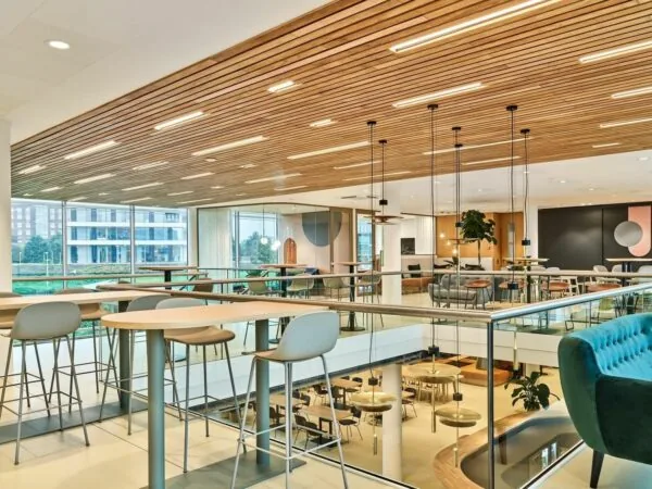 Moderne kantoorruimte aan de Van Deventerlaan 30-40 met open zithoeken, hoge ramen en een houten plafond.