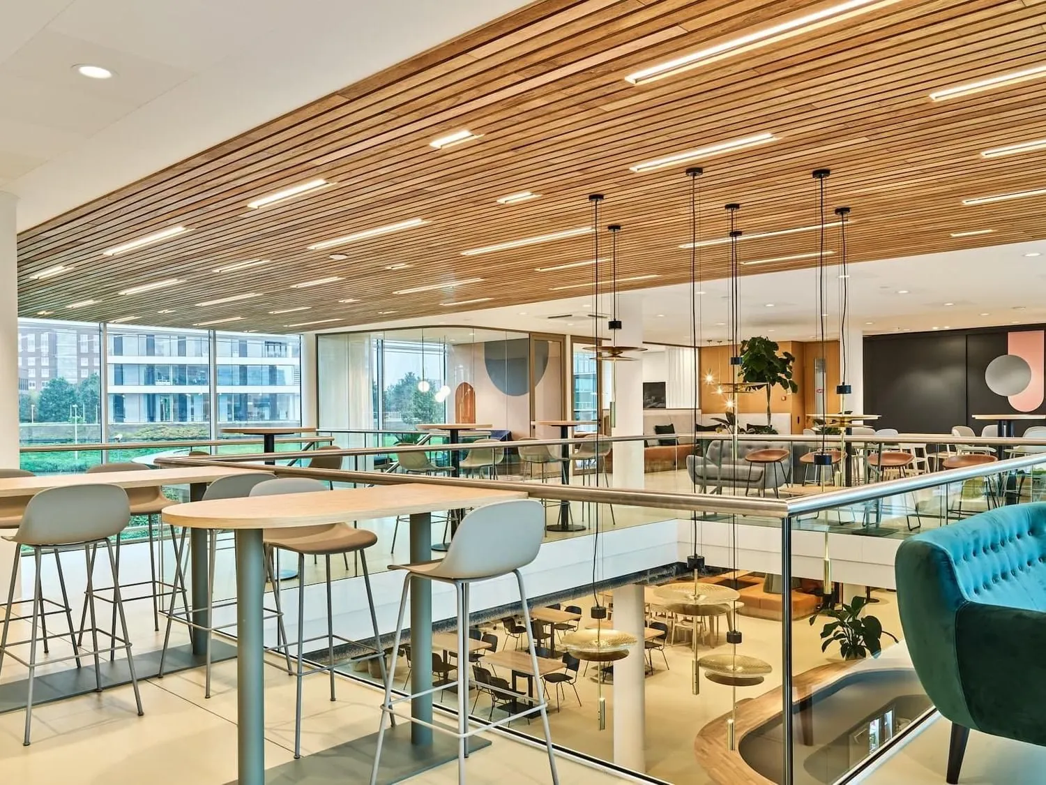 Moderne kantoorruimte aan de Van Deventerlaan 30-40 met open zithoeken, hoge ramen en een houten plafond.