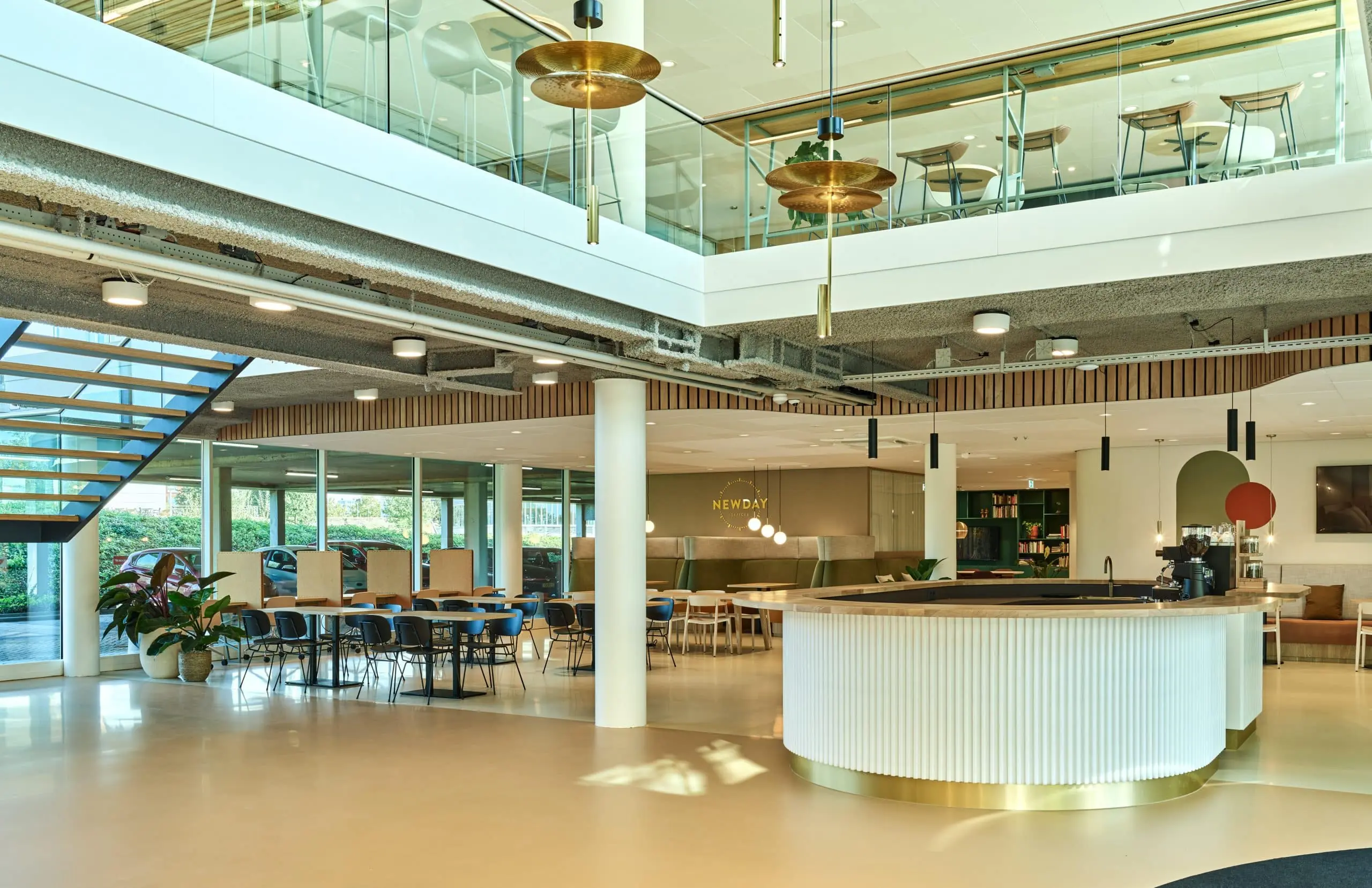 Moderne, open kantoorlounge aan de Van Deventerlaan 30-40 met zithoeken, vergadertafels en een centraal koffiepunt.