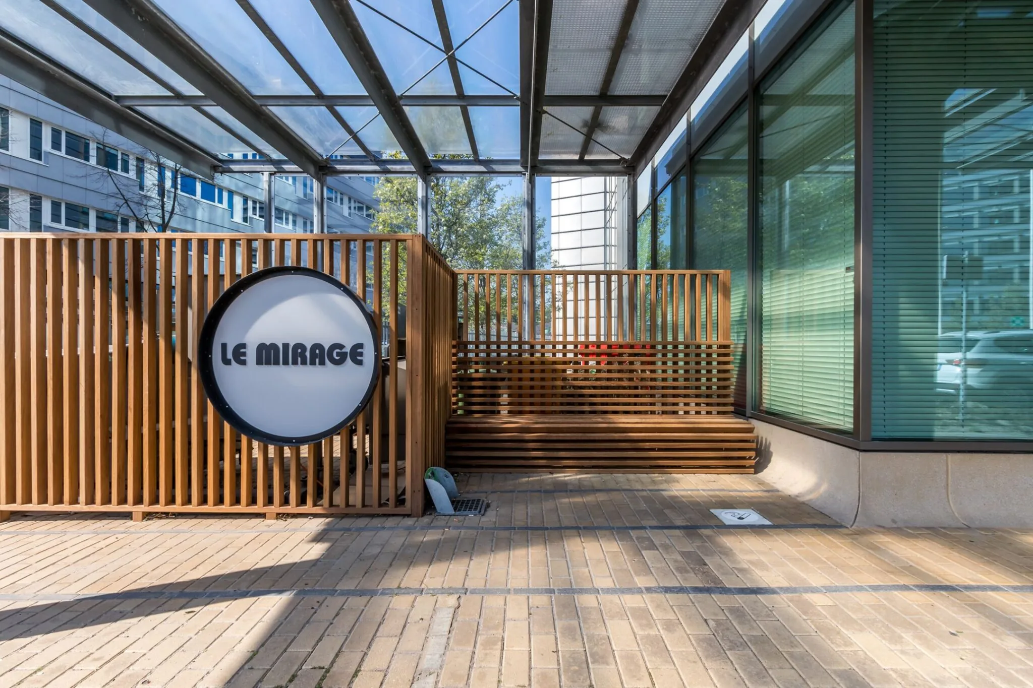Ingang van Le Mirage aan de Vliegend Hertlaan met houten lamellenwand en overkapping.